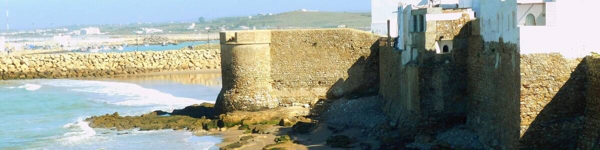 Asilah (Arabic: أصيلة، Aṣīla; Berber: ⴰⵥⵉⵍⴰ Aẓila; "authentic", Portuguese: Arzila, Spanish: Arcila) is a fortified town on the northwest tip of the Atlantic coast of Morocco, about 31 km (19 mi) south of Tangier. Its ramparts and gateworks remain fully intact.
The town's history dates back to 1500 B.C., when the Phoenicians used it as a base for trade. The Portuguese conquered the city in 1471, but later it was decided to abandon it because of an economic debt crisis in 1549. Later in 1578, Sebastian of Portugal used Asilah as a base town for his troops during a planned crusade that resulted in Sebastian's death, which in turn caused the Portuguese succession crisis of 1580. The Moroccans in 1589 regained control of Asilah briefly, but then lost control of it to the Spanish.
In 1692, the town was again taken by the Moroccans under the leadership of Moulay Ismail. Asilah served then as a base for pirates in the 19th and 20th centuries, and in 1829, the Austrians punitively bombarded the city due to Moroccan piracy.
From 1912 to 1956, it was part of Spanish Morocco. A major plan to restore the town was undertaken in 1978 by its mayor, Mohamed Benaissa. The first edition of an art festival known as the International Cultural Moussem of Asilah was launched that year to help generate tourism. It was successful in generating revenue for the city and played a role in raising the average monthly income from $50 in 1978 to $140 in 2014. The festival features local artwork and music and continues to attract large amounts of tourists.
Asilah is now a popular seaside resort, with modern holiday apartment complexes on the coast road leading to the town from Tangier.