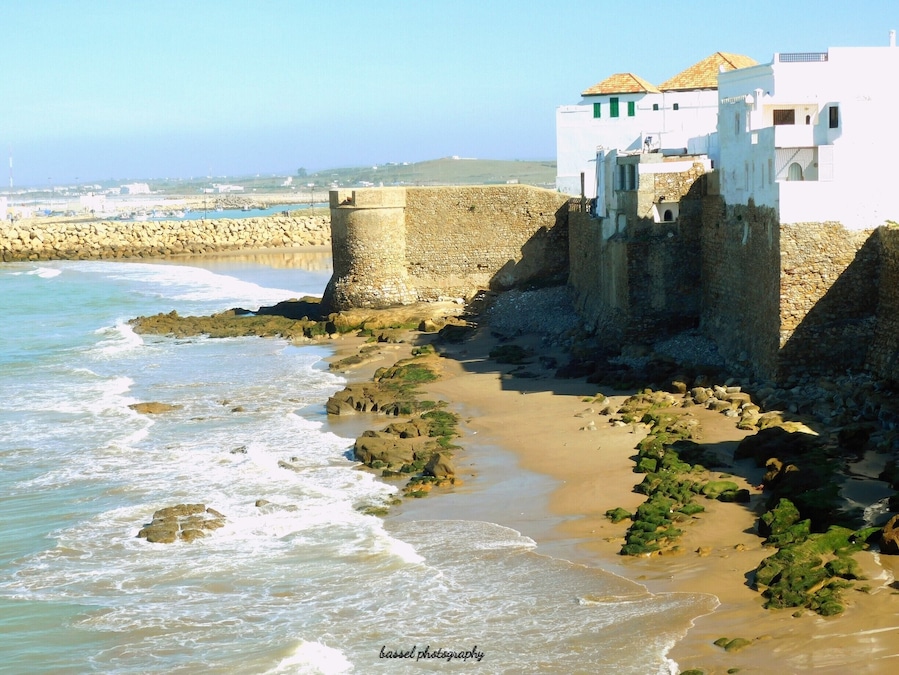 Asilah (Arabic: أصيلة، Aṣīla; Berber: ⴰⵥⵉⵍⴰ Aẓila; "authentic", Portuguese: Arzila, Spanish: Arcila) is a fortified town on the northwest tip of the Atlantic coast of Morocco, about 31 km (19 mi) south of Tangier. Its ramparts and gateworks remain fully intact.
The town's history dates back to 1500 B.C., when the Phoenicians used it as a base for trade. The Portuguese conquered the city in 1471, but later it was decided to abandon it because of an economic debt crisis in 1549. Later in 1578, Sebastian of Portugal used Asilah as a base town for his troops during a planned crusade that resulted in Sebastian's death, which in turn caused the Portuguese succession crisis of 1580. The Moroccans in 1589 regained control of Asilah briefly, but then lost control of it to the Spanish.
In 1692, the town was again taken by the Moroccans under the leadership of Moulay Ismail. Asilah served then as a base for pirates in the 19th and 20th centuries, and in 1829, the Austrians punitively bombarded the city due to Moroccan piracy.
From 1912 to 1956, it was part of Spanish Morocco. A major plan to restore the town was undertaken in 1978 by its mayor, Mohamed Benaissa. The first edition of an art festival known as the International Cultural Moussem of Asilah was launched that year to help generate tourism. It was successful in generating revenue for the city and played a role in raising the average monthly income from $50 in 1978 to $140 in 2014. The festival features local artwork and music and continues to attract large amounts of tourists.
Asilah is now a popular seaside resort, with modern holiday apartment complexes on the coast road leading to the town from Tangier.