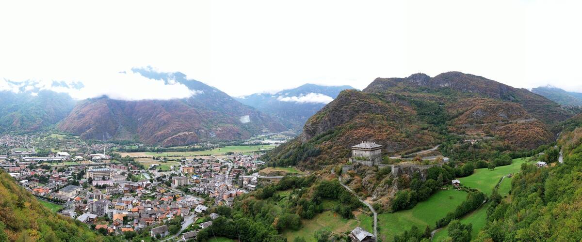 A town nestled in a valley with mountains in the background.