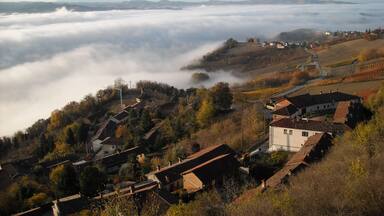 A village nestled among rolling hills and a blanket of clouds.