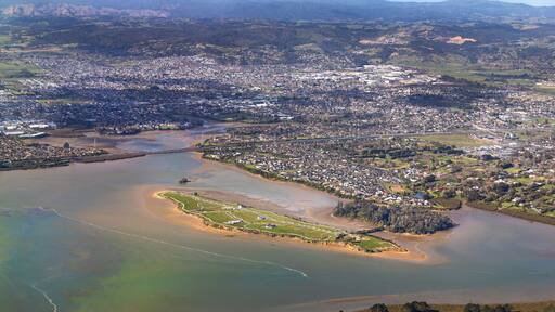 Pararekau Island and Manukau Harbour, Auckland, New Zealand, aerial view. Development in 2025 of gated exclusive subdivision on the island. Motorway, Karaka, Papakura, Takanini and Ardmore in distance