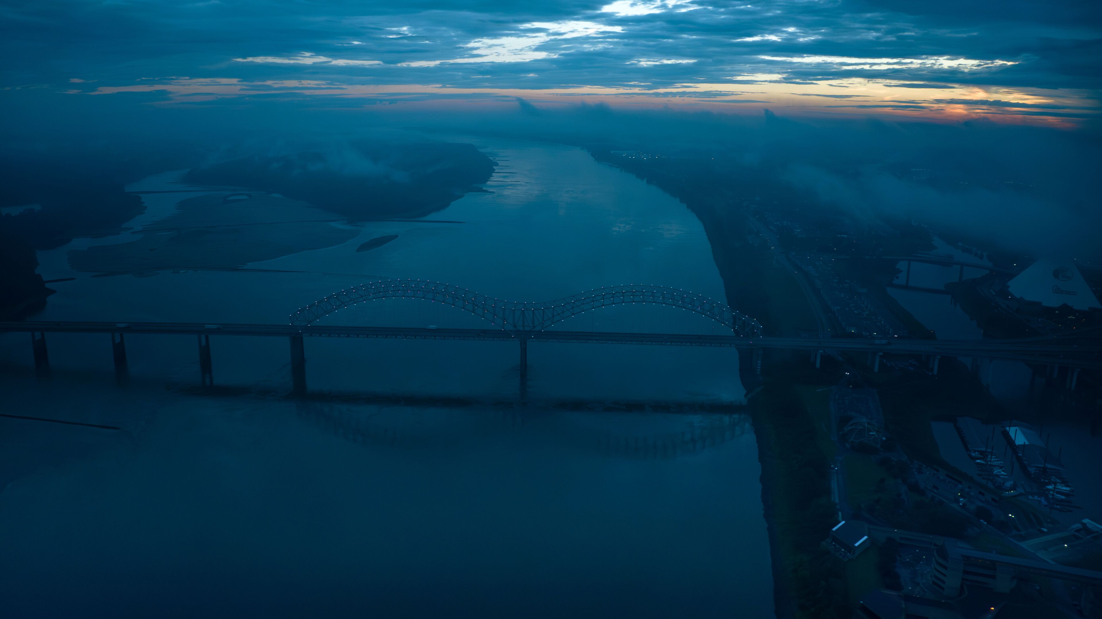 JULY 6, 2023 - MEMPHIS, TN, USA - Hernando De Soto Bridge to Memphis, Tennessee over Mississippi River at dusk with low clouds