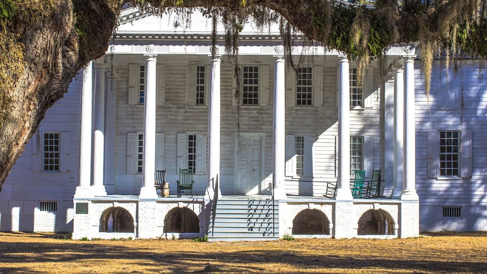 A white colonial-style building with columns and a covered porch.