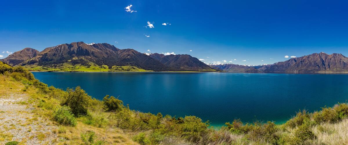 A lake surrounded by mountains and greenery.