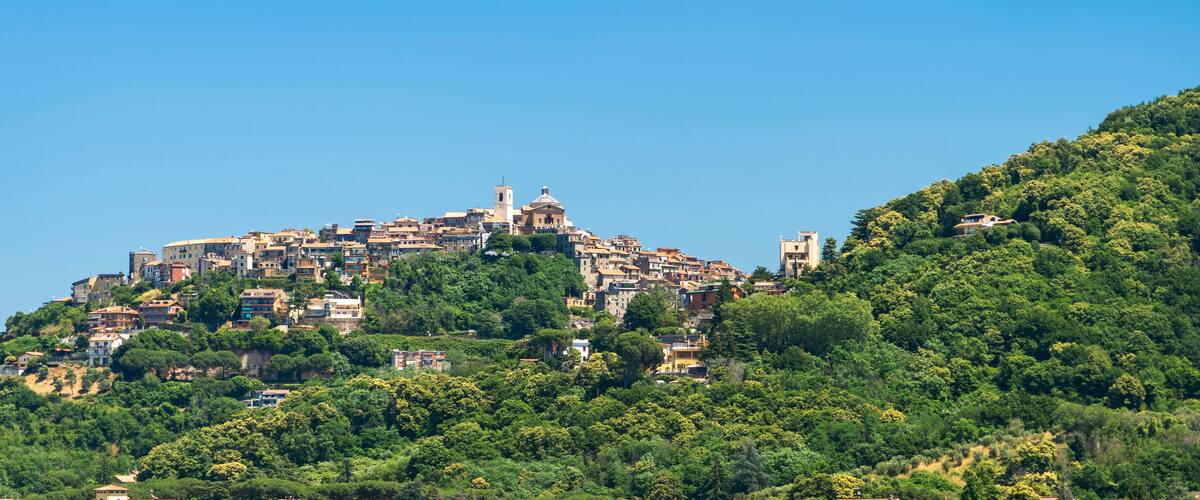 A densely packed hillside town with historic buildings and a prominent church on top.