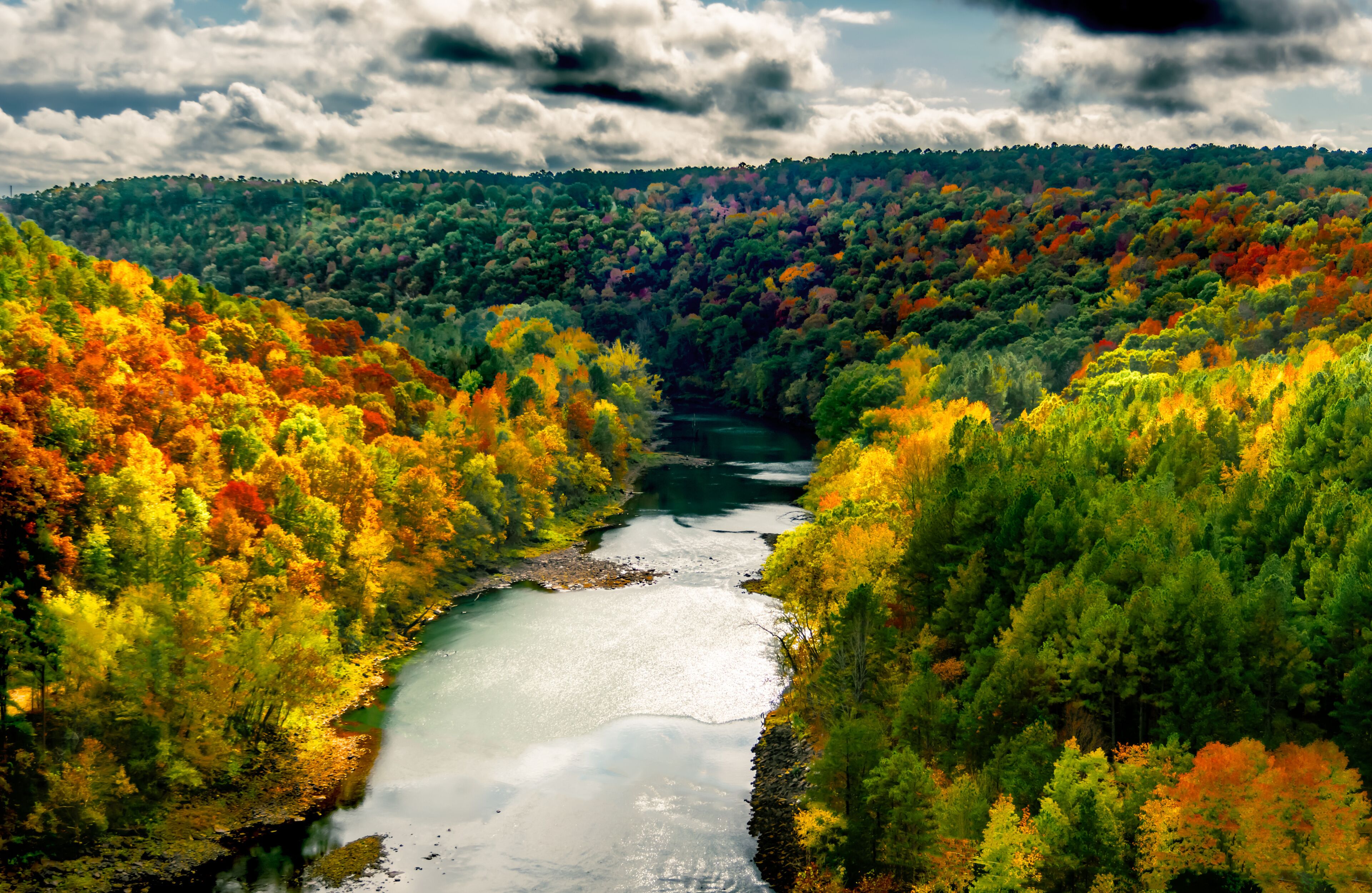 A river winding through a forest with autumn foliage.