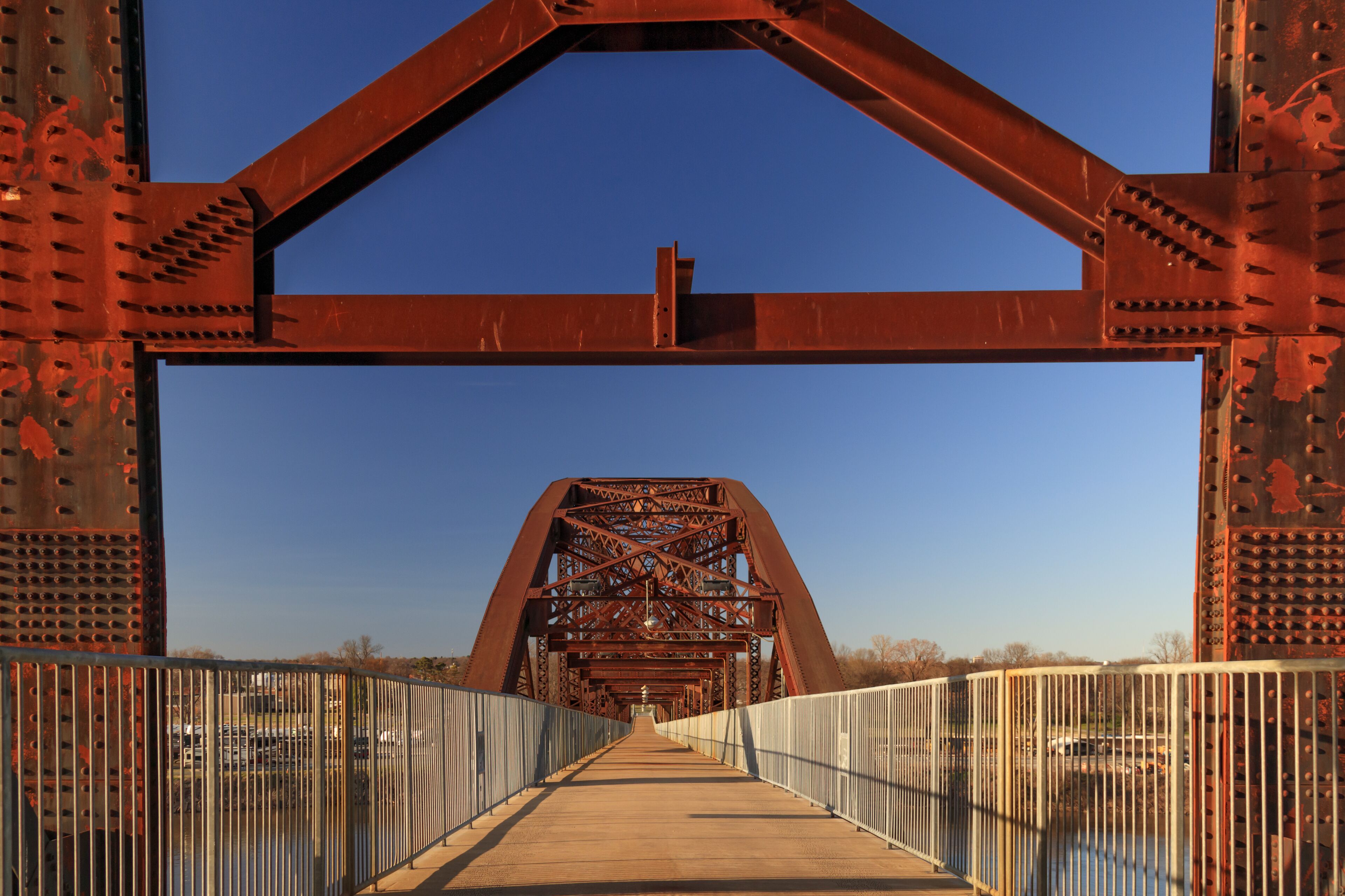 A large, rusted metal bridge with a metal walkway and railings.