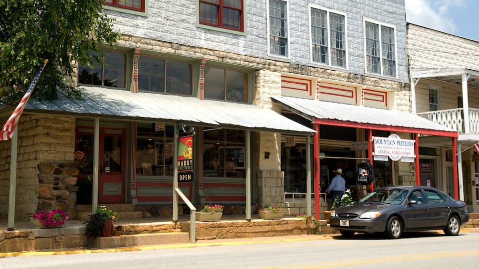 A storefront with a sign reading "Mountain Peddlers" and a man standing outside.