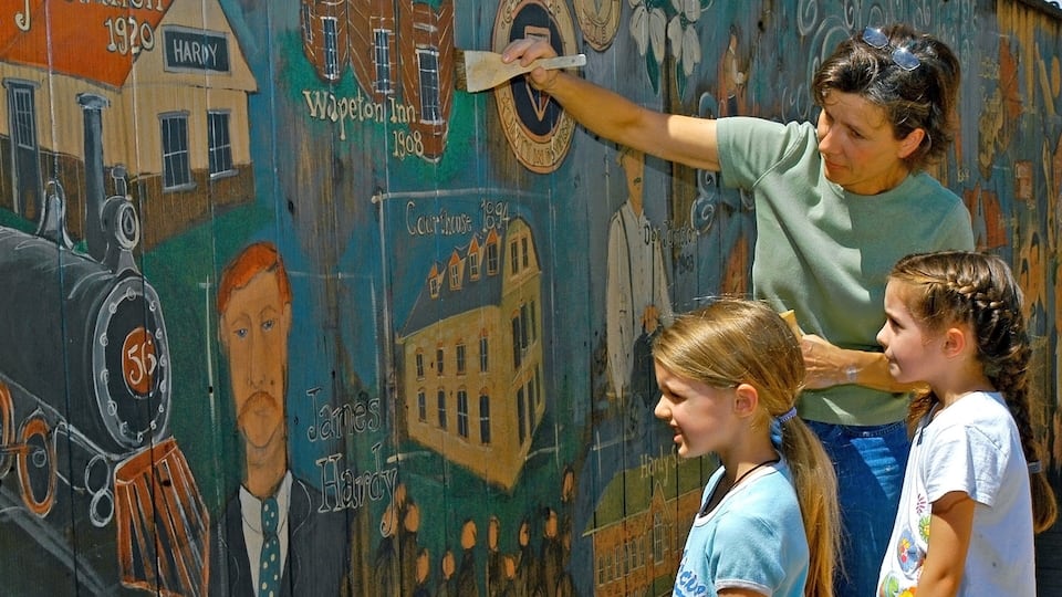 A mural with historical buildings and figures.