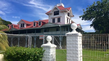 A large, white colonial-style building with a red roof, surrounded by a white fence and a sign that reads "SILLIMAN".