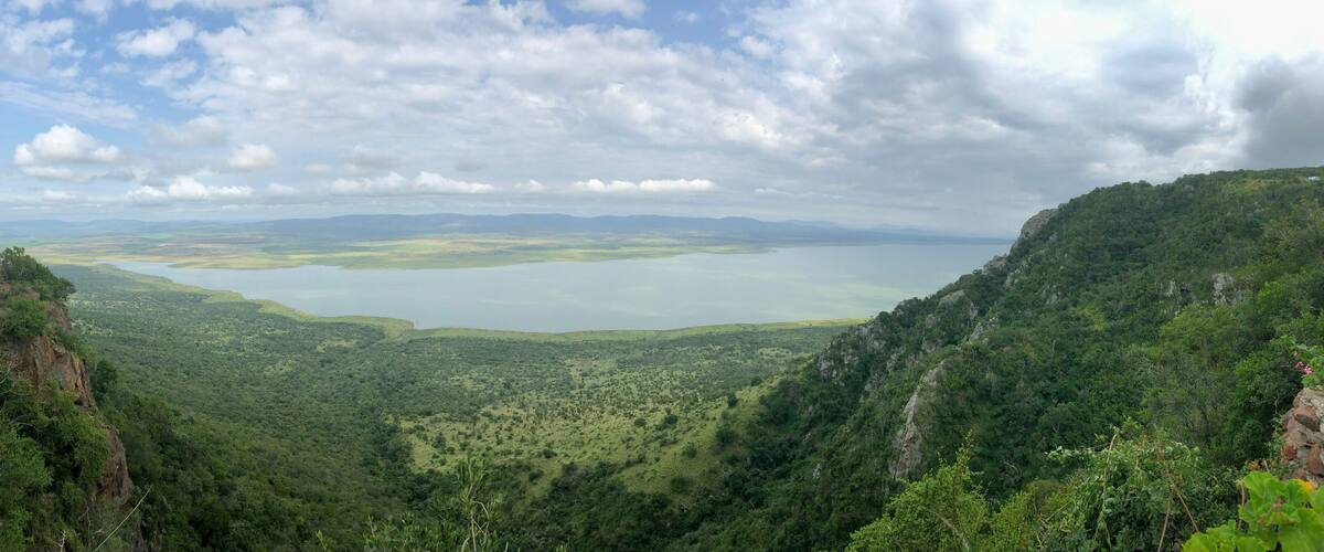 A mountainous landscape with a lake and distant mountains.
