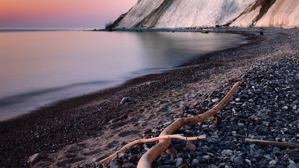 MĂžns Klint is a 6 km stretch of chalk cliffs along the eastern coast of the Danish island of MĂžn in the Baltic Sea. Some of the cliffs fall a sheer 120 m to the sea below.
Visit the Geocenter MĂžns Klint in the daytime - or watch the stars on the beautiful night sky in this Dark Sky area.
#sunrise #ocean #longexposure #pebble #cliff #darksky #chalk #morning