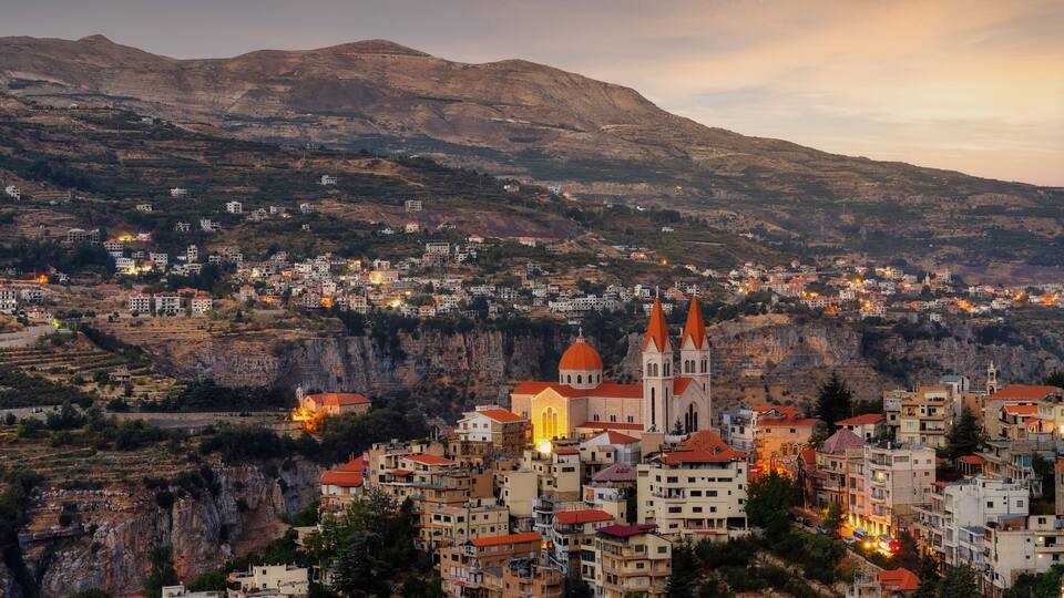 A mountainous town with a prominent church and residential buildings.