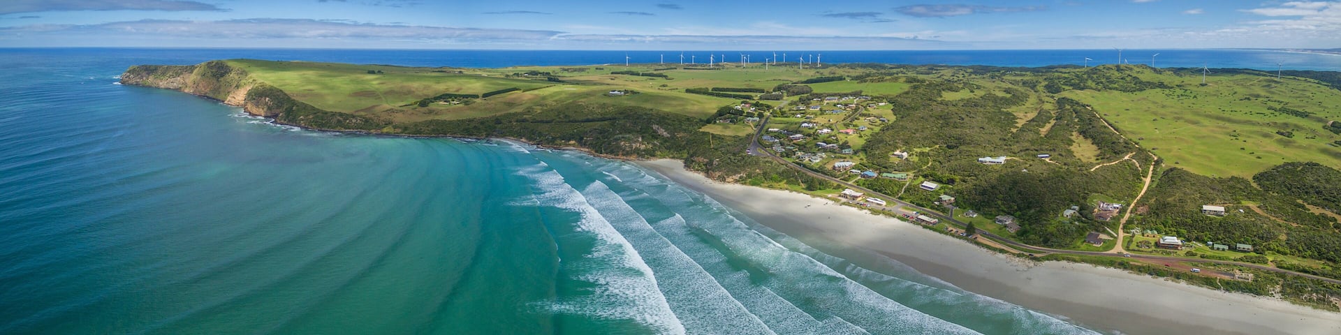 Aerial panorama of Cape Bridgewater beach, settlement, and wind farm in Victoria, Australia