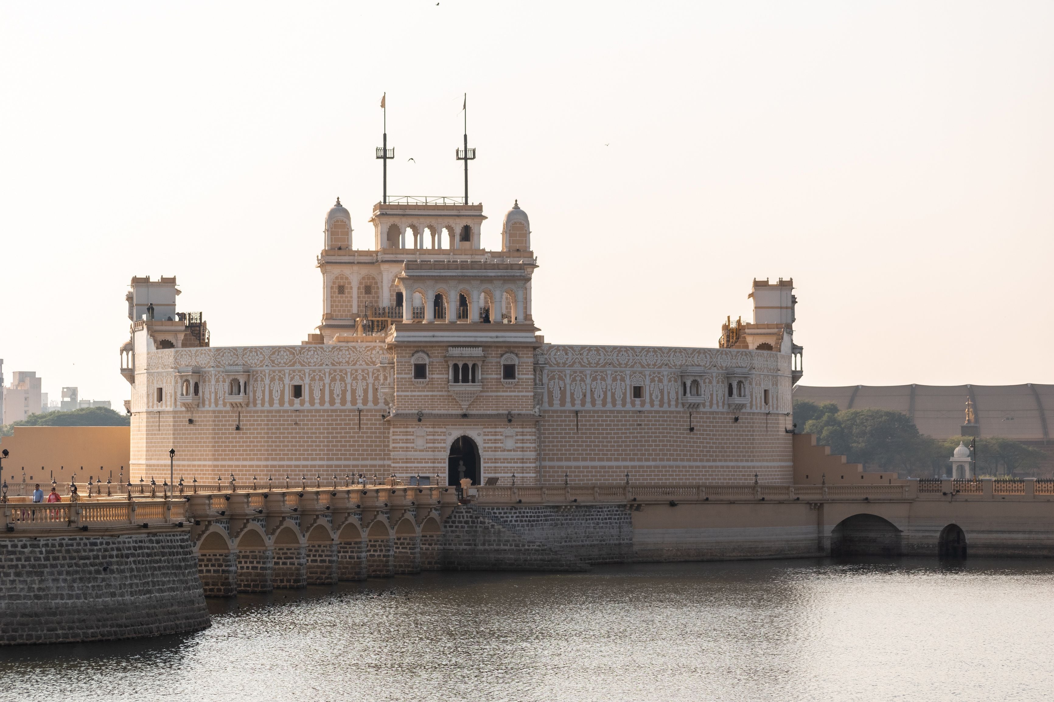 A large, ornate building with multiple towers and a bridge over a body of water.