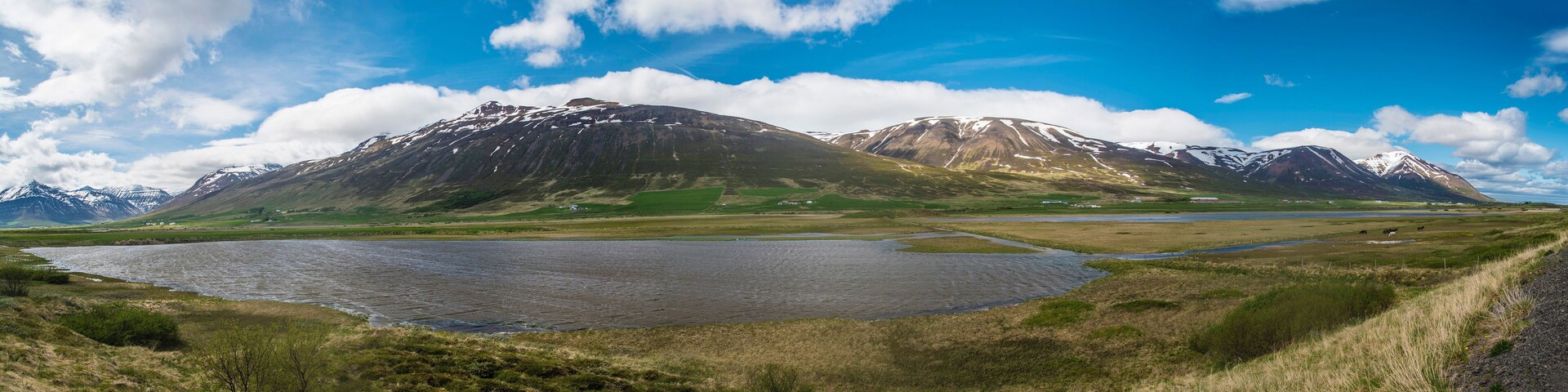 Paisagem montanhosa com um lago e um rio.