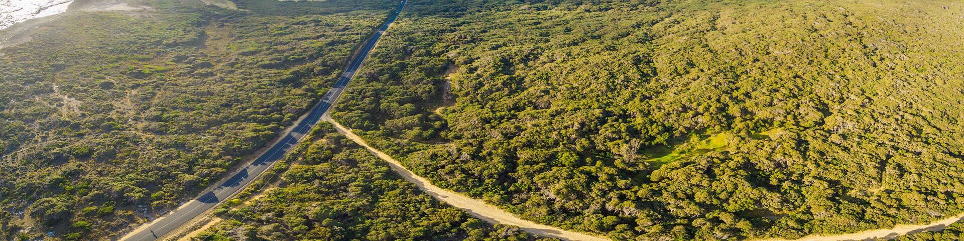 Aerial panorama of rural road passing through beautiful Australian countryside on bright spring day