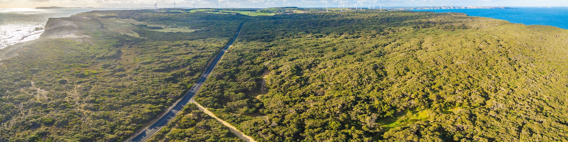 Aerial panorama of rural road passing through beautiful Australian countryside on bright spring day