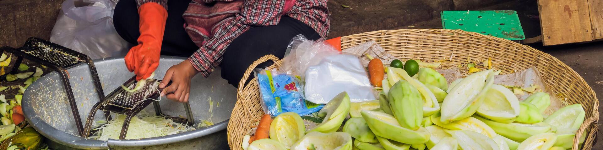 R4ABRG Woman grating green papaya for salad at Psar Chas Old Market in the centre of Siem Reap, the important north west tourist town, Siem Reap, Cambodia