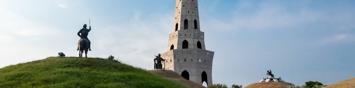 wide shot of fateh burj with sikh warrior statue against blue sky in the background. historical monument concept.