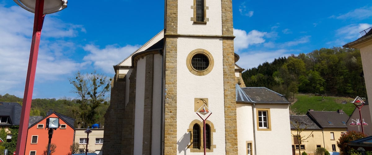 A church with a tall steeple and a clock tower.