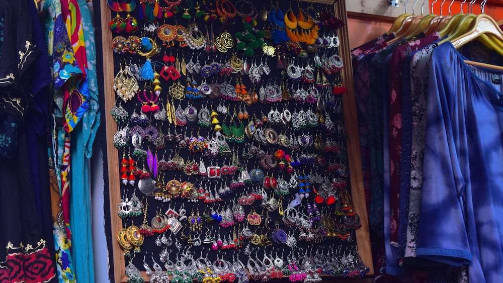 A display of colorful jewelry and clothing items in a shop.