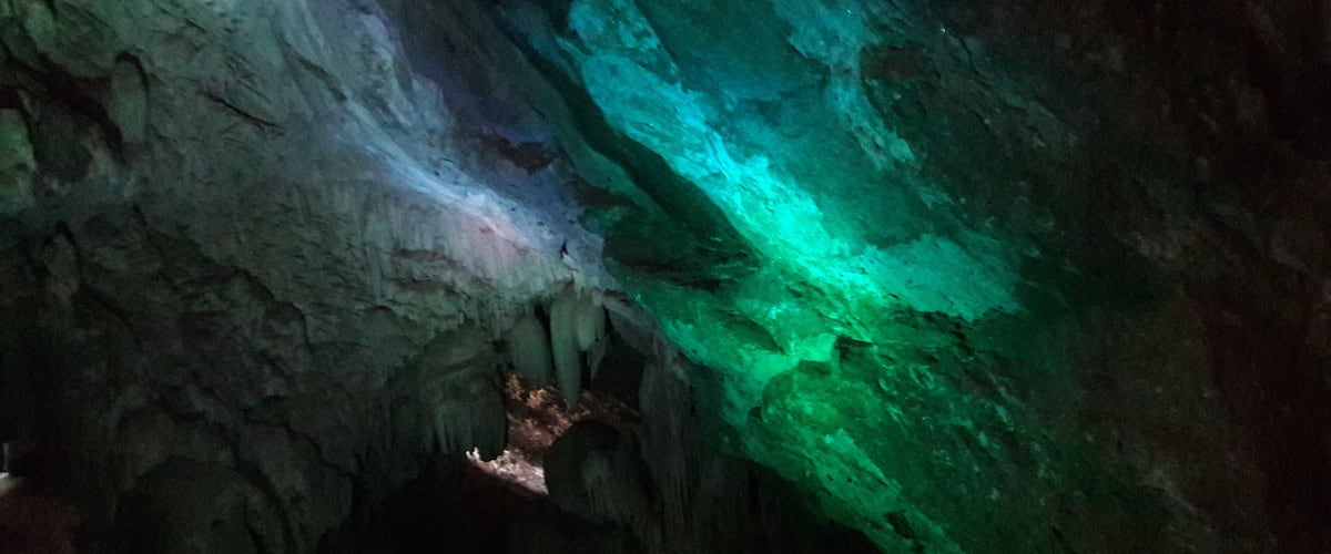 A cave with green and blue lighting.