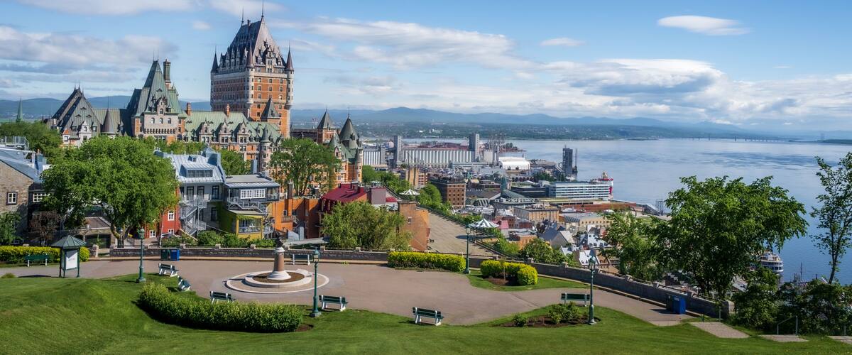 A historic castle, a waterfront, and a park with benches.