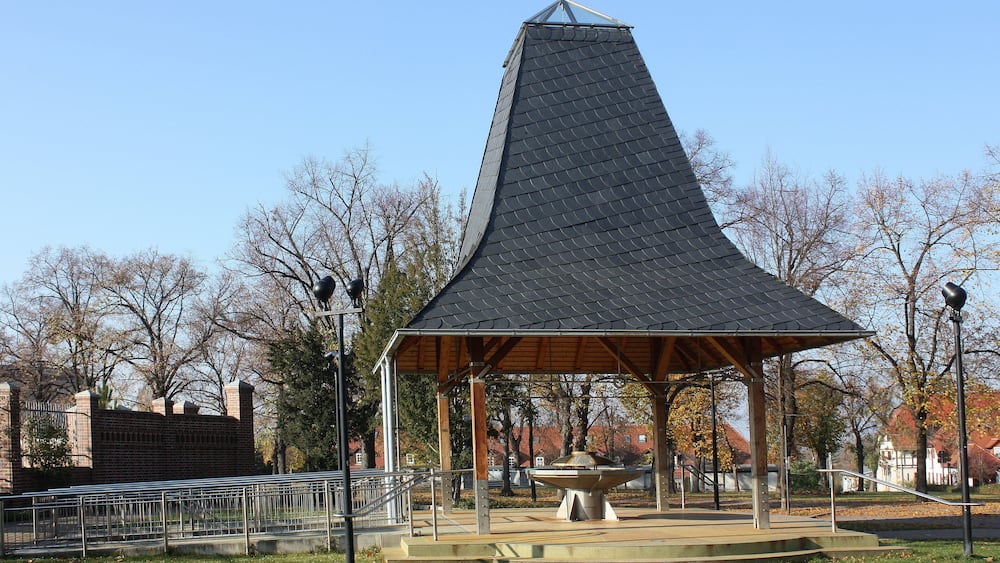 Ein Pavillon mit einem markanten Kegeldach in einem Park.