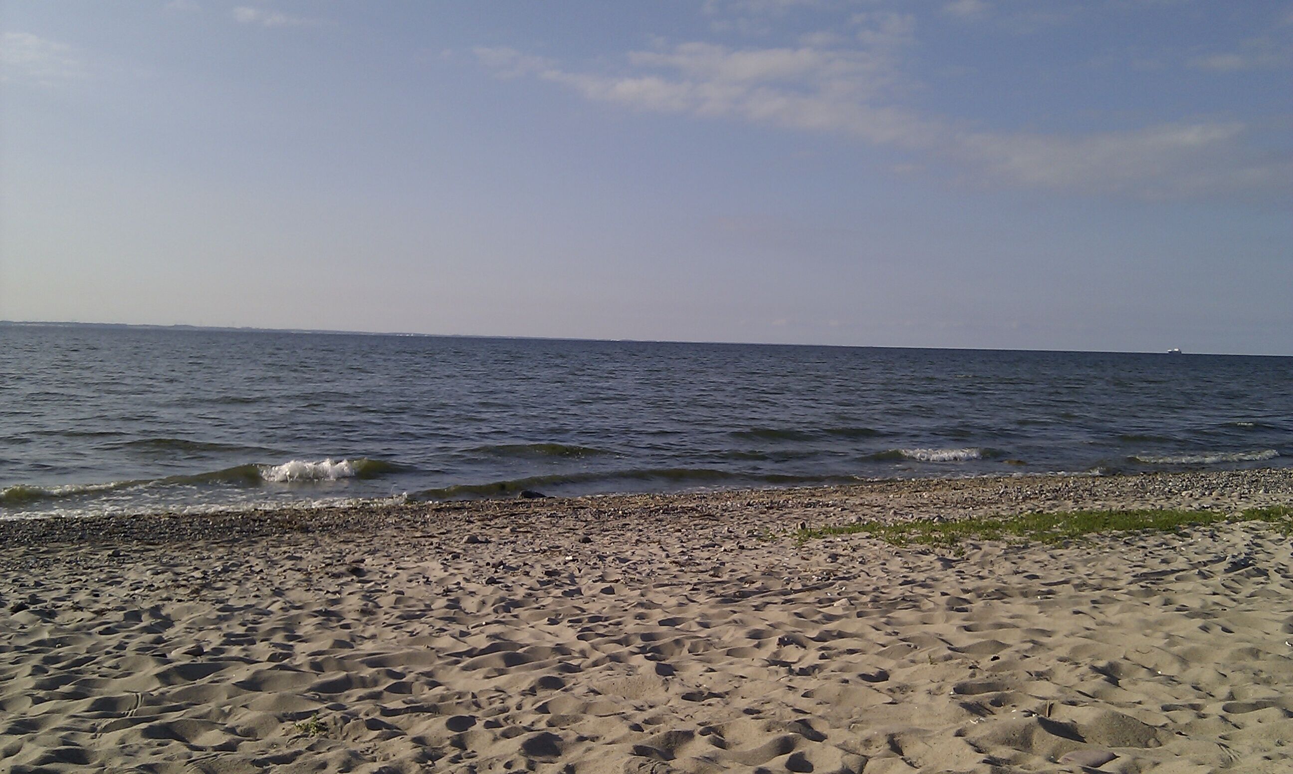 A beach with pebbles and waves.