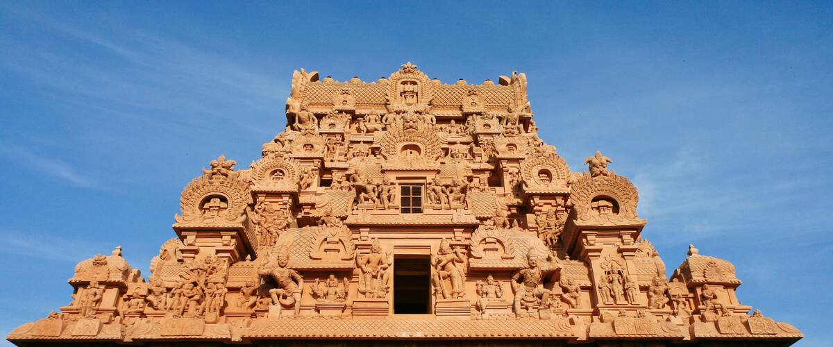 A detailed sandstone temple with intricate carvings and a central doorway.