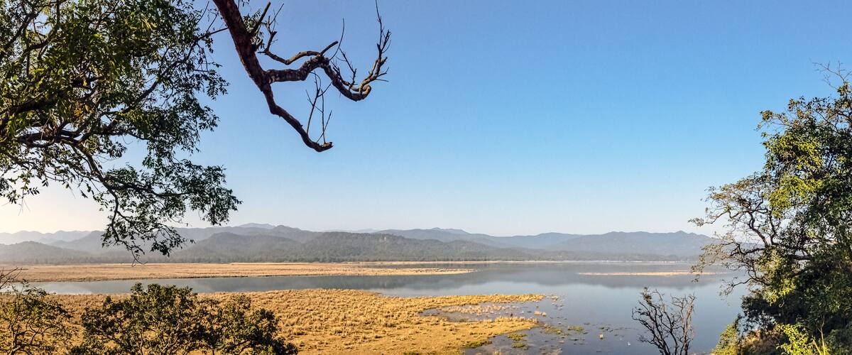 A lake surrounded by dry grassland and mountains.
