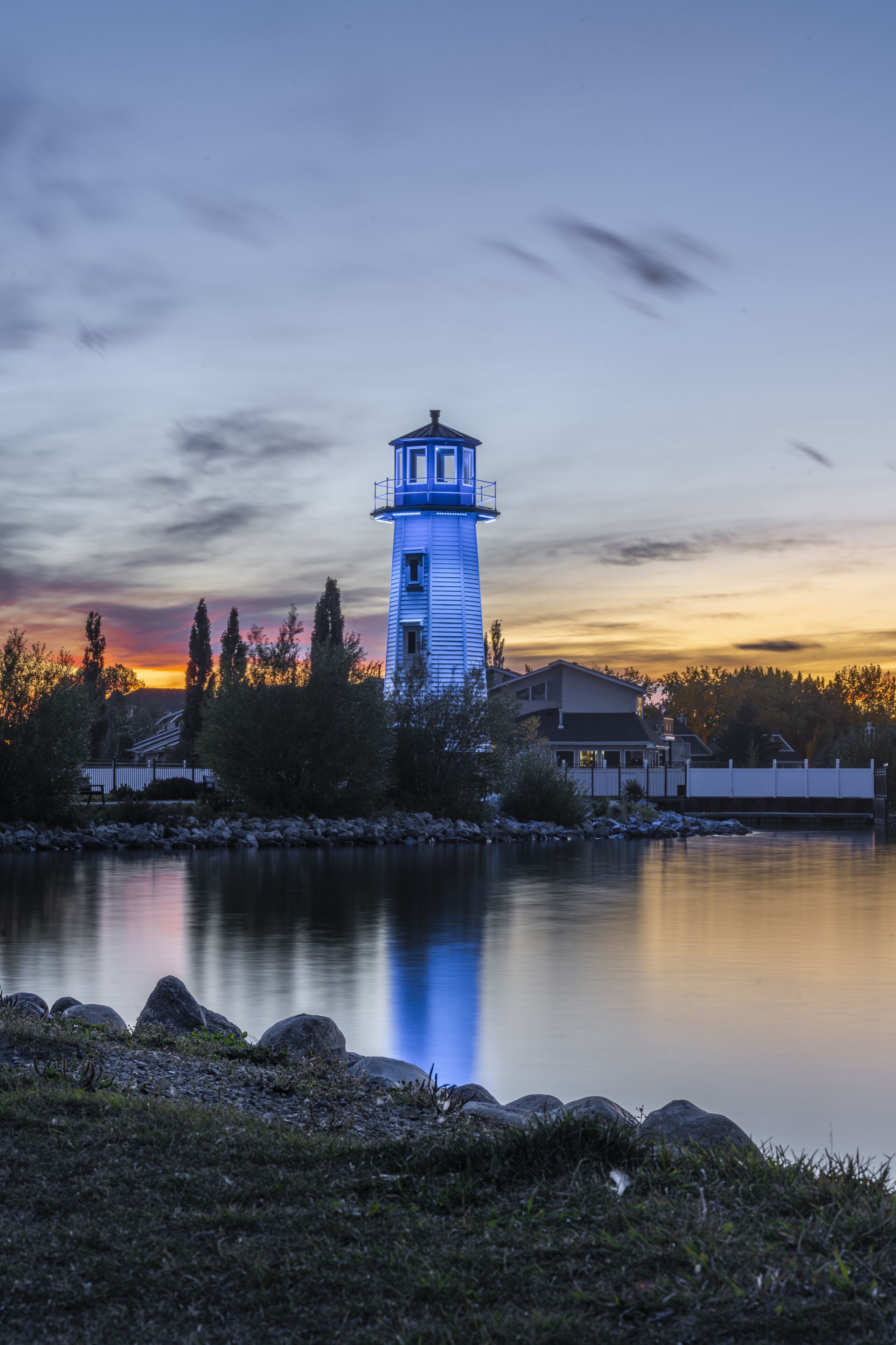 Vertical shot of a blue lighthouse near the shore of Sylvan Lake in Alberta, Canada
