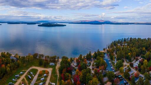 Aerial view of Lake Winnipesaukee in fall with Ossipee Mountains at the background, from Ellacoya State Park in town of Gilford, New Hampshire NH, USA. This mountains belong to White Mountains.