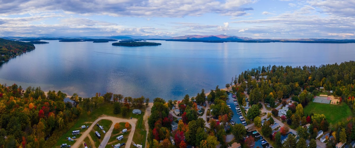 Aerial view of Lake Winnipesaukee in fall with Ossipee Mountains at the background, from Ellacoya State Park in town of Gilford, New Hampshire NH, USA. This mountains belong to White Mountains.