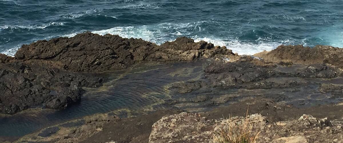 A rocky coastline with waves crashing against the rocks.