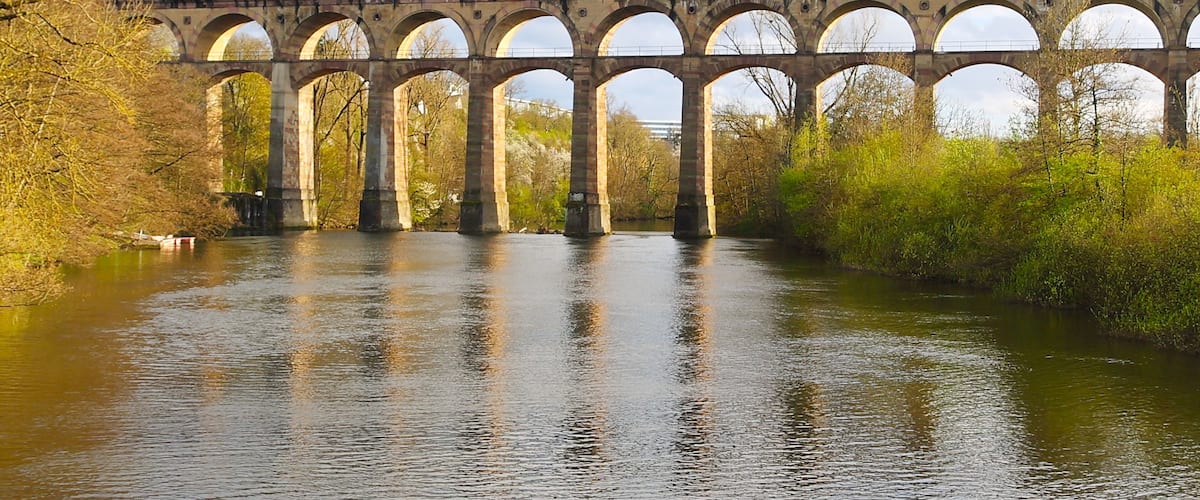 A stone viaduct with multiple arches spanning a river.