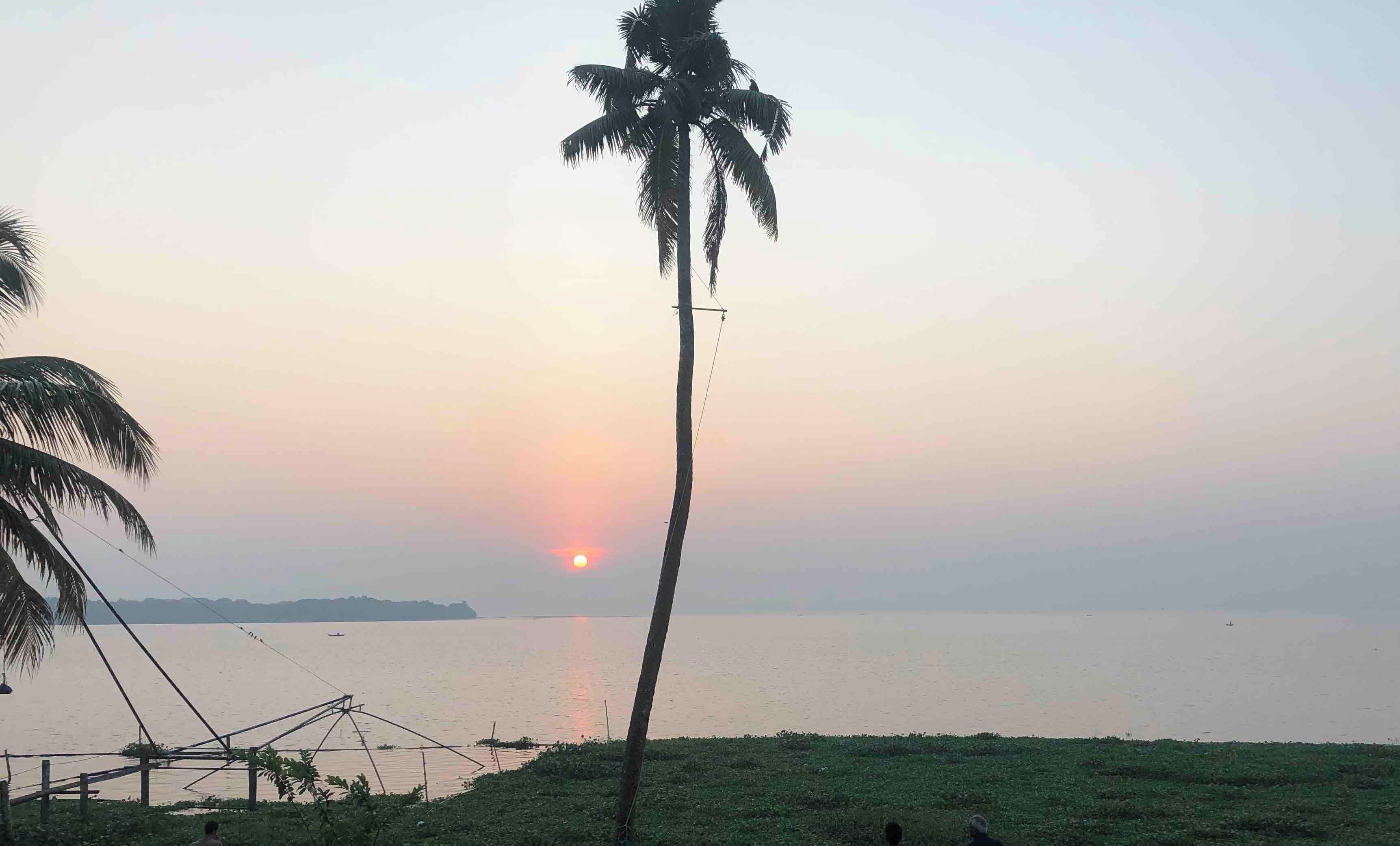 Beautiful sunrise on the backwaters of Kerala, South India. Tranquil and calming Lake Vembanad.