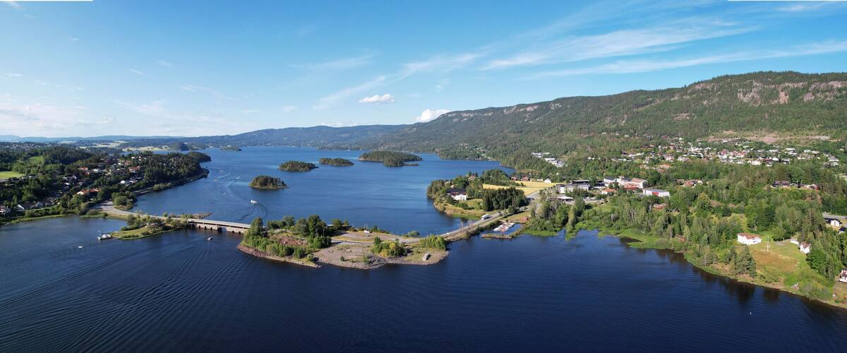 A lake surrounded by forested hills and small towns.