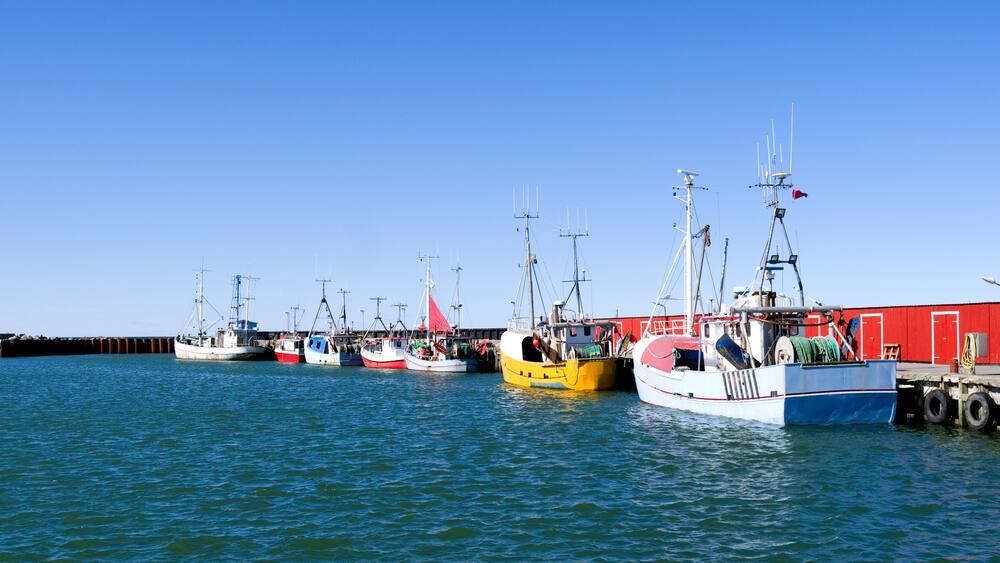 Laesoe / Denmark: Fishing cutters moored in a row at the pier in the small fishing port of Oesterby Havn in April
