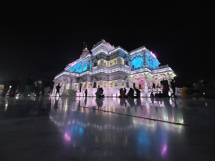 A brightly lit temple with intricate architecture and a reflective ground.