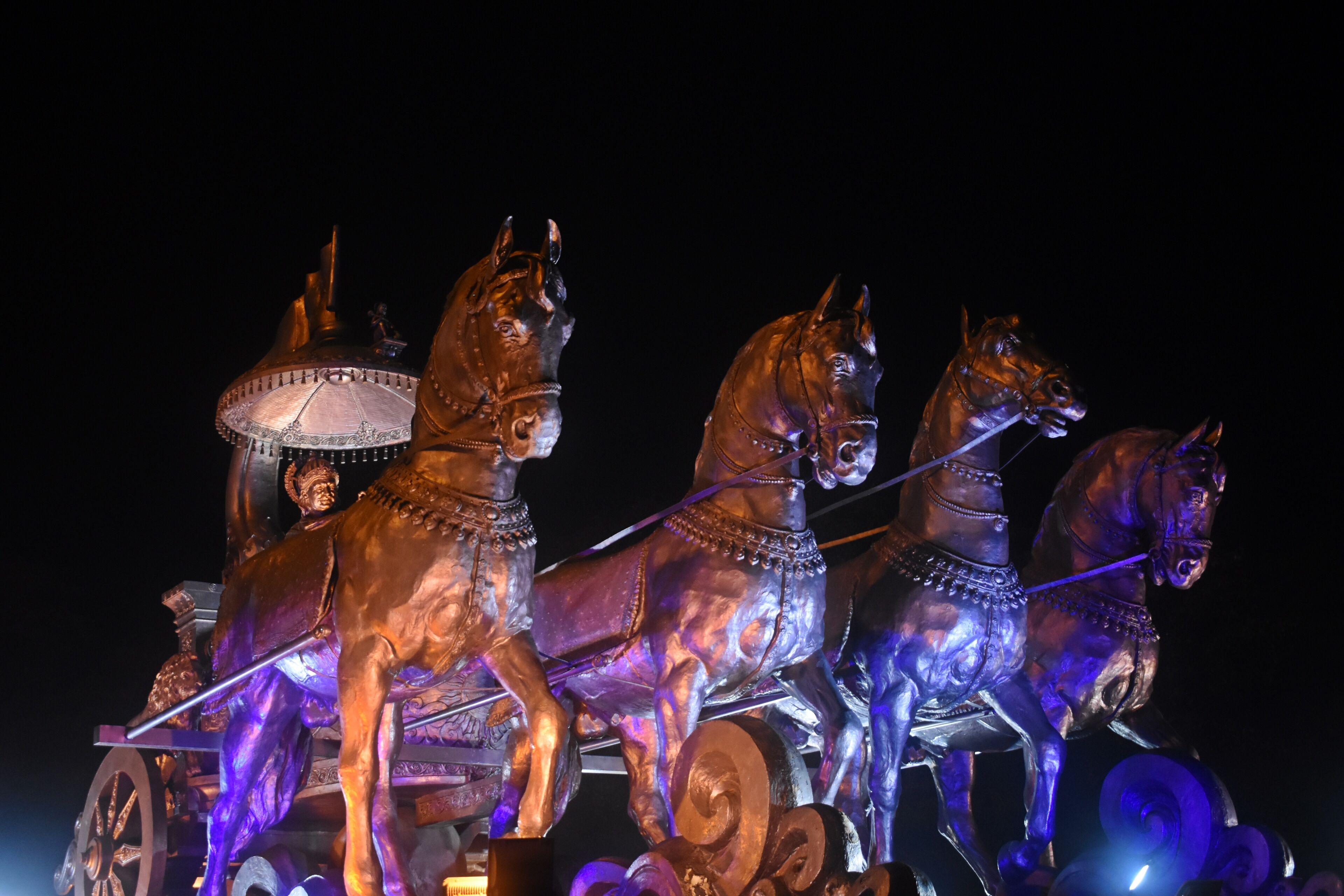 "Illuminated Bronze Chariot Statue of Krishna and Arjuna at Night in Kurukshetra, Haryana, India"