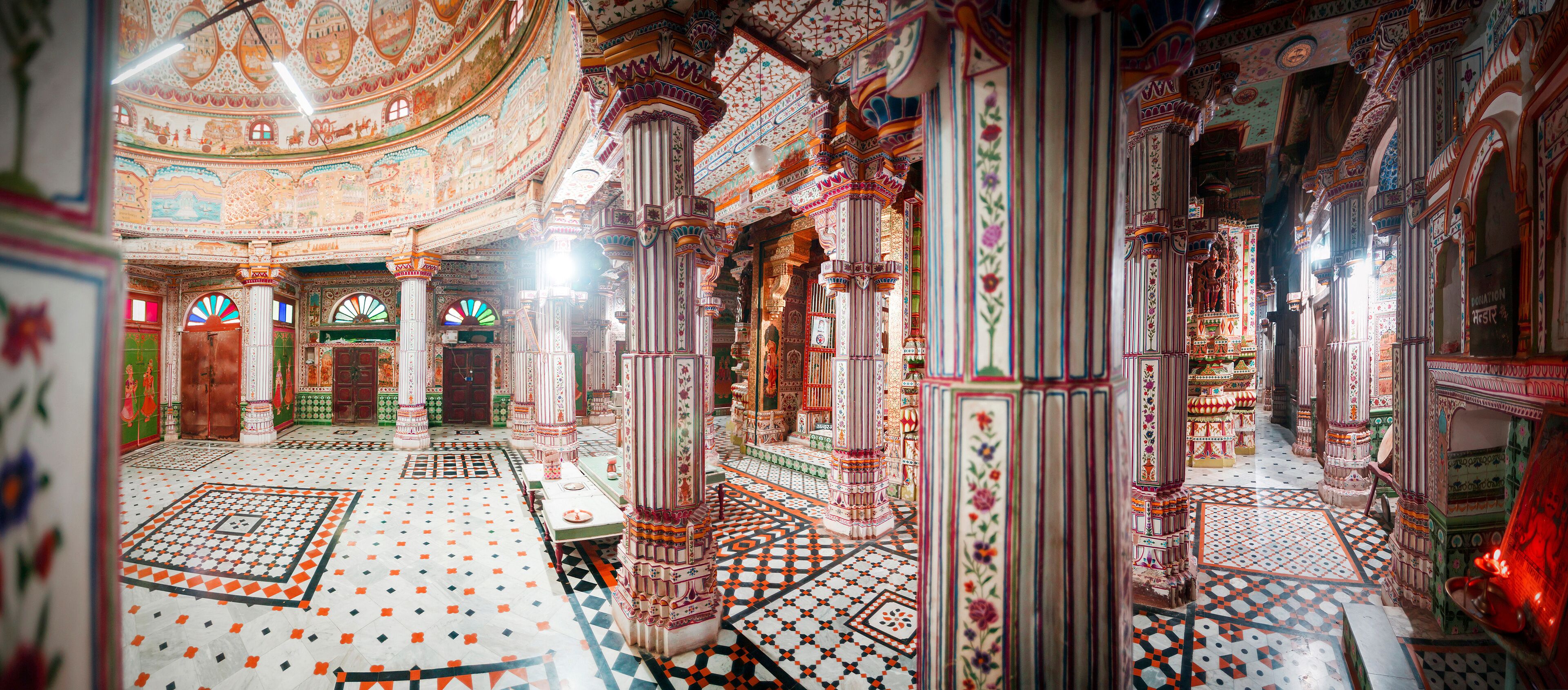 An intricately decorated interior with patterned floors and ornate columns.