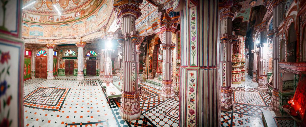 An intricately decorated interior with patterned floors and ornate columns.