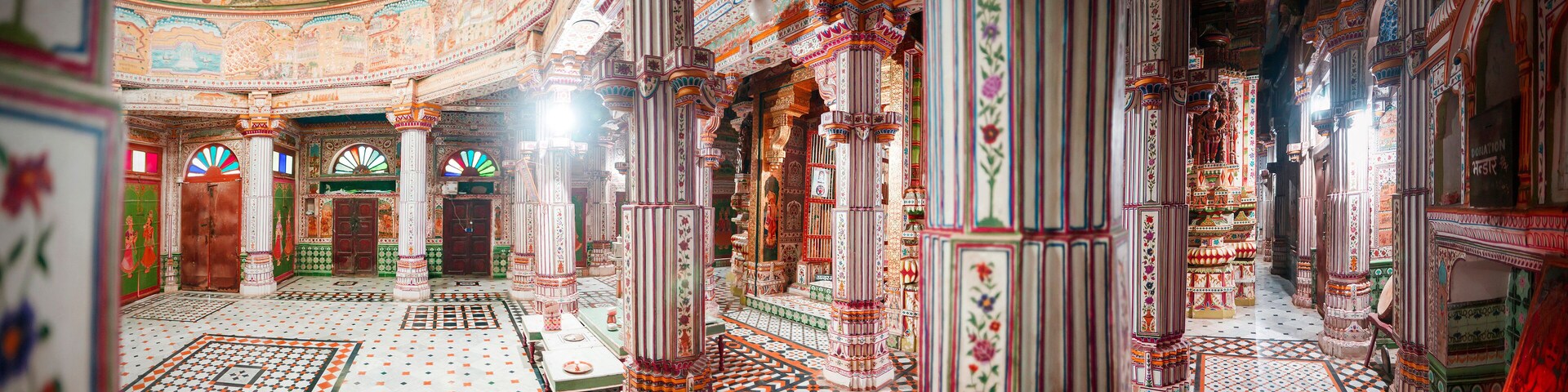 An intricately decorated interior with patterned floors and ornate columns.
