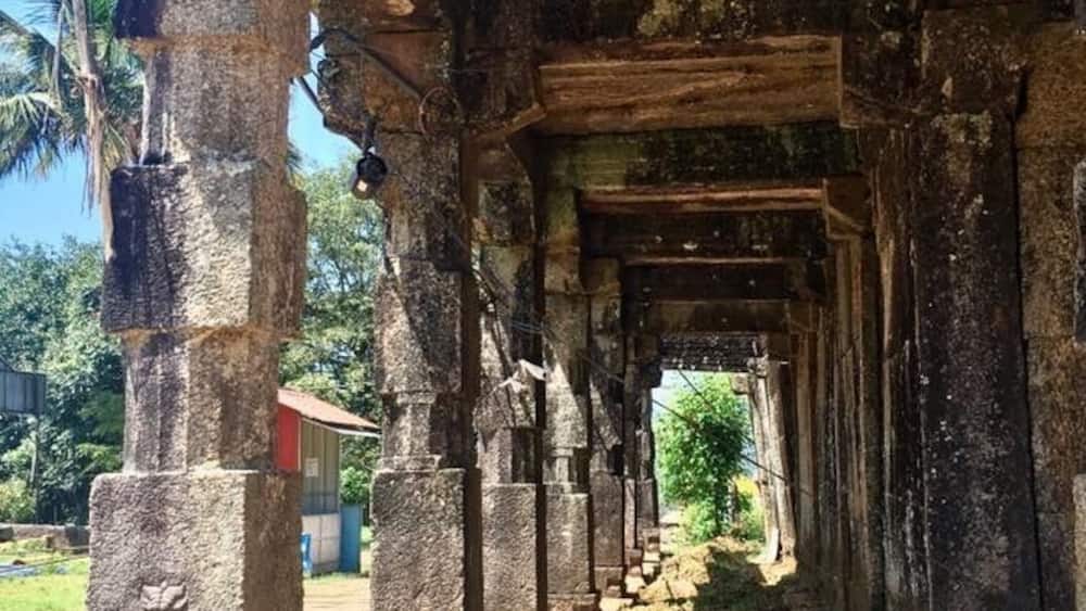 An ancient stone structure with a series of pillars and a central passageway.