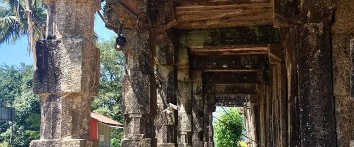 An ancient stone structure with a series of pillars and a central passageway.