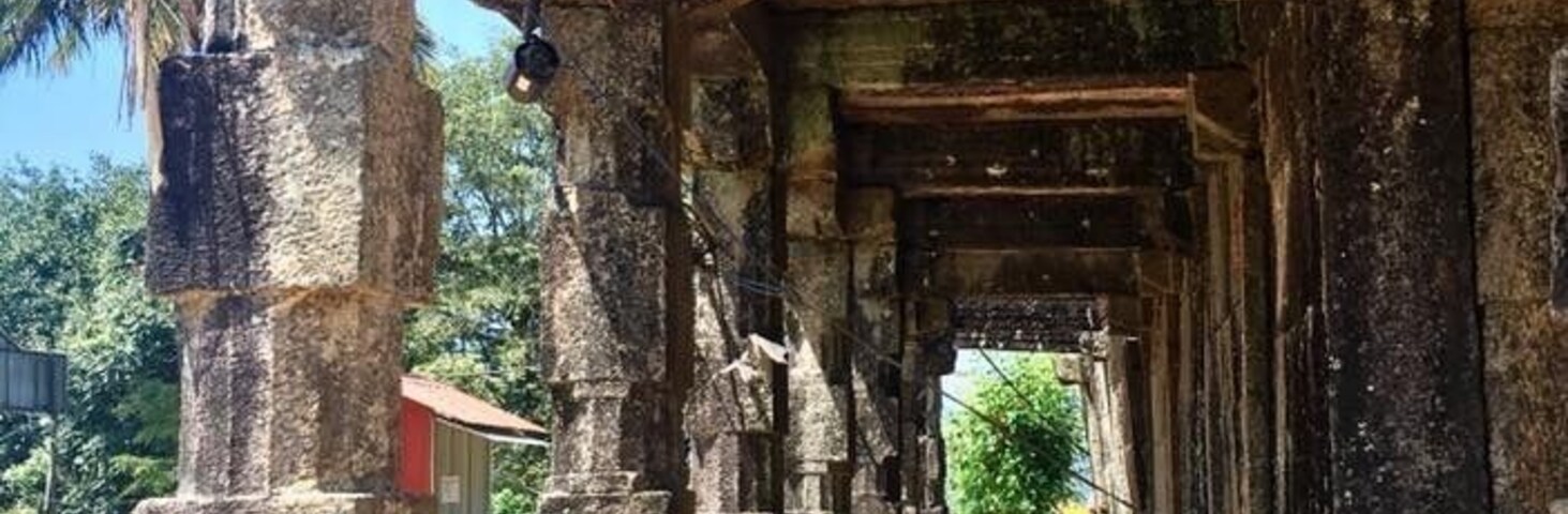 An ancient stone structure with a series of pillars and a central passageway.