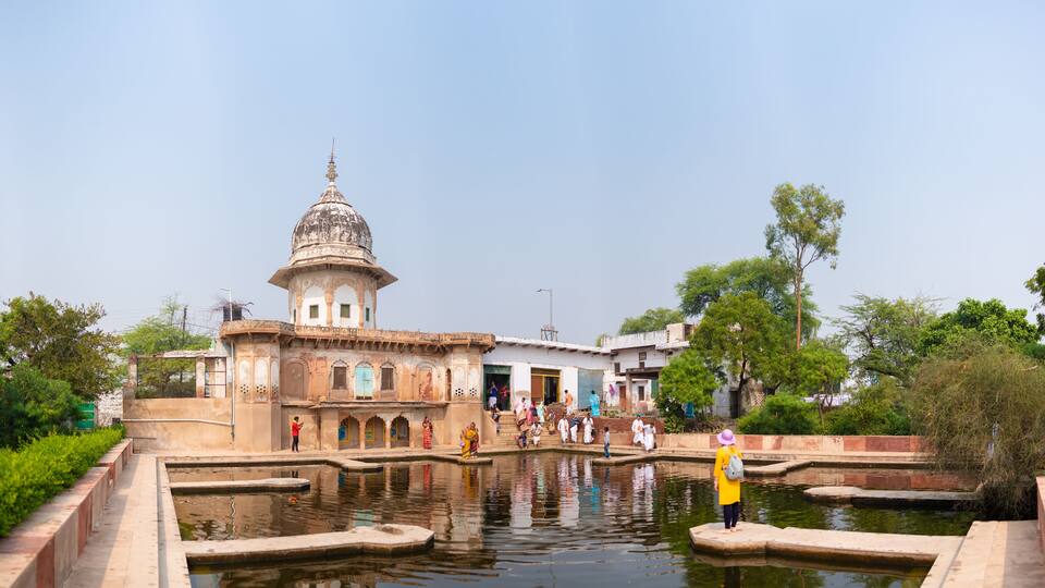 A historic building with a dome and a water body in front.