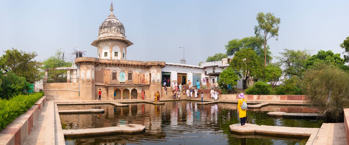 A historic building with a dome and a water body in front.